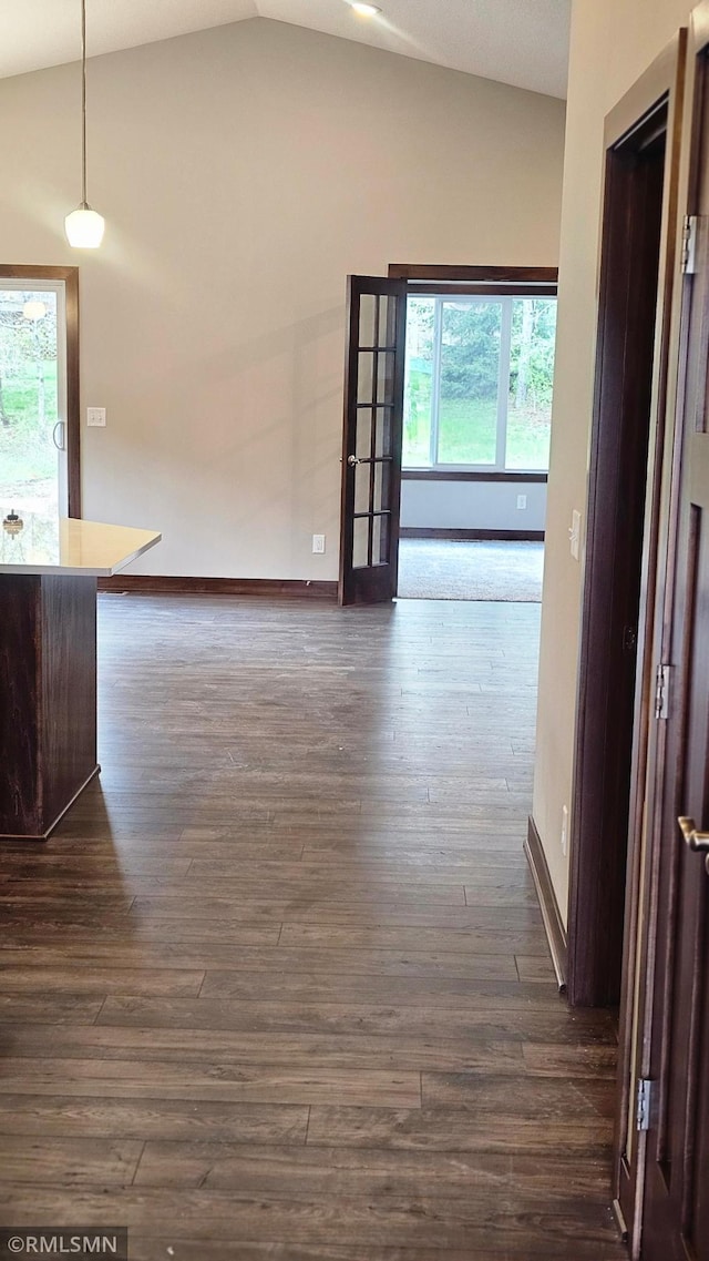 corridor with vaulted ceiling and hardwood / wood-style floors