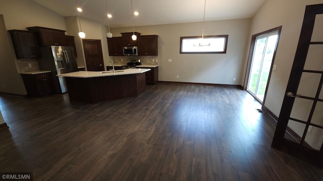 kitchen featuring stainless steel appliances, dark brown cabinets, backsplash, a kitchen island with sink, and dark hardwood / wood-style floors