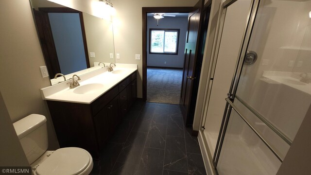 bathroom featuring a shower with door, toilet, vanity, and ceiling fan