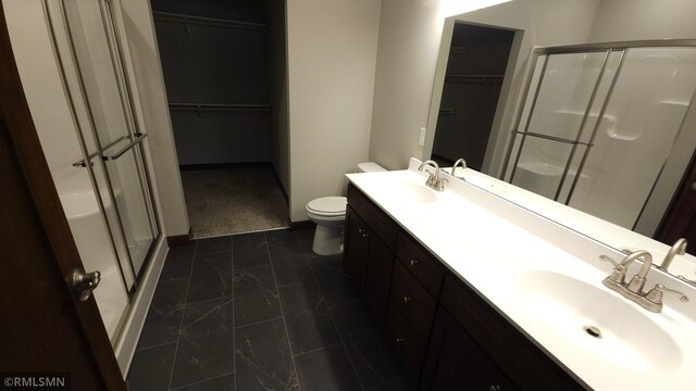 bathroom featuring toilet, tile patterned flooring, an enclosed shower, and double vanity