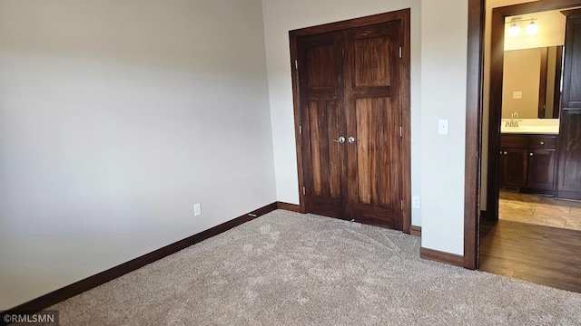 unfurnished bedroom featuring sink, carpet, and connected bathroom