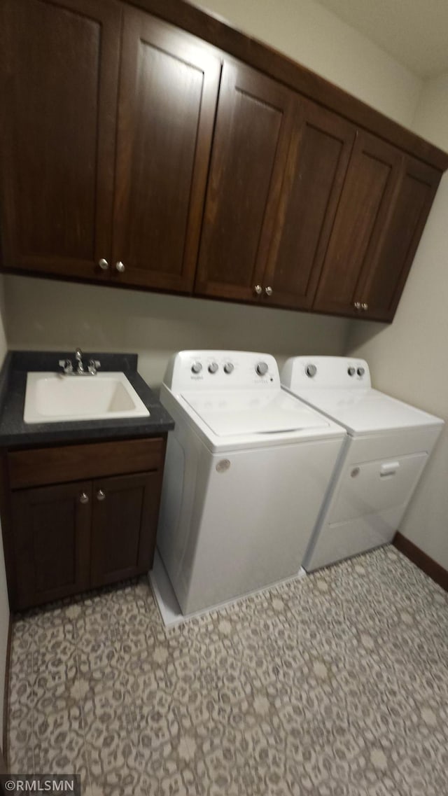 laundry room featuring cabinets, washing machine and dryer, sink, and light tile patterned floors