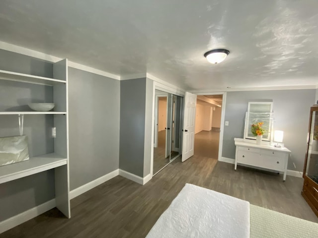 hall featuring dark wood-style flooring and baseboards