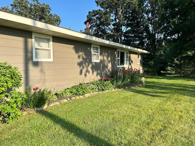 view of side of home with a yard