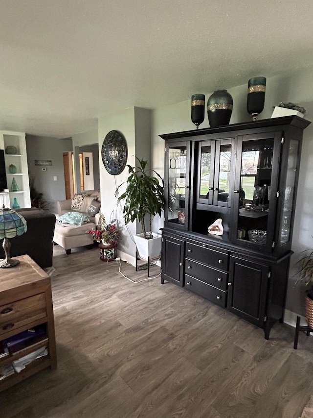 living room with baseboards and dark wood-style flooring