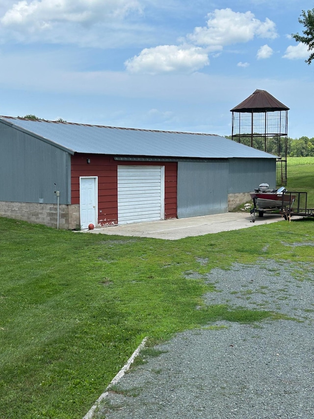 view of pole building with driveway and a lawn