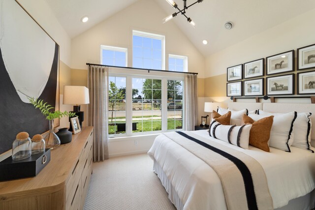 carpeted bedroom featuring high vaulted ceiling and a notable chandelier