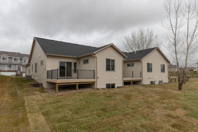 rear view of house featuring central air condition unit, a deck, and a lawn