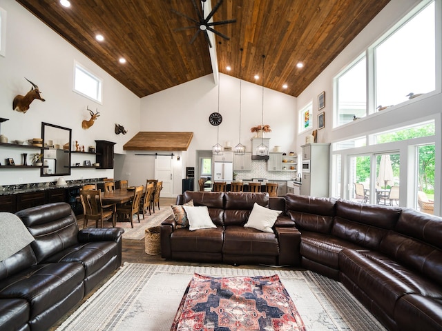 living room with ceiling fan, hardwood / wood-style flooring, plenty of natural light, and high vaulted ceiling