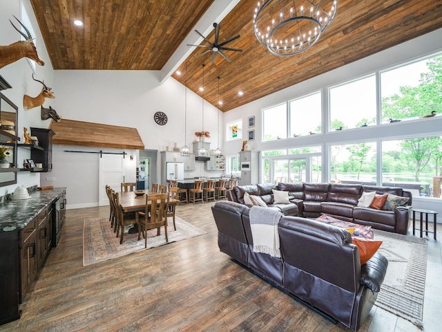 living room featuring dark hardwood / wood-style floors, ceiling fan with notable chandelier, a barn door, high vaulted ceiling, and wooden ceiling