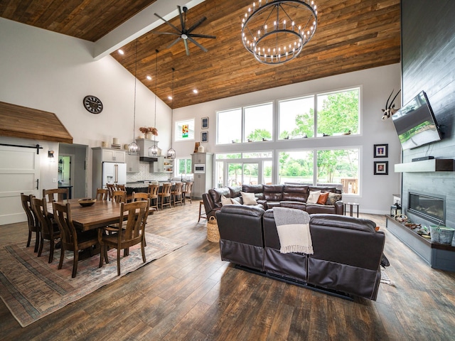 living room with wooden ceiling, ceiling fan with notable chandelier, a fireplace, and high vaulted ceiling