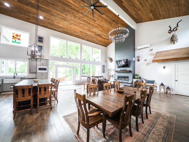 dining space with high vaulted ceiling, a large fireplace, ceiling fan with notable chandelier, and wood ceiling