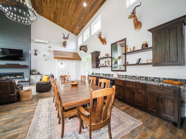 dining room featuring a notable chandelier, a large fireplace, dark wood-type flooring, and high vaulted ceiling