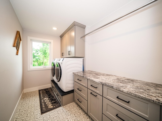 laundry room featuring washer and clothes dryer, cabinets, and light tile patterned floors