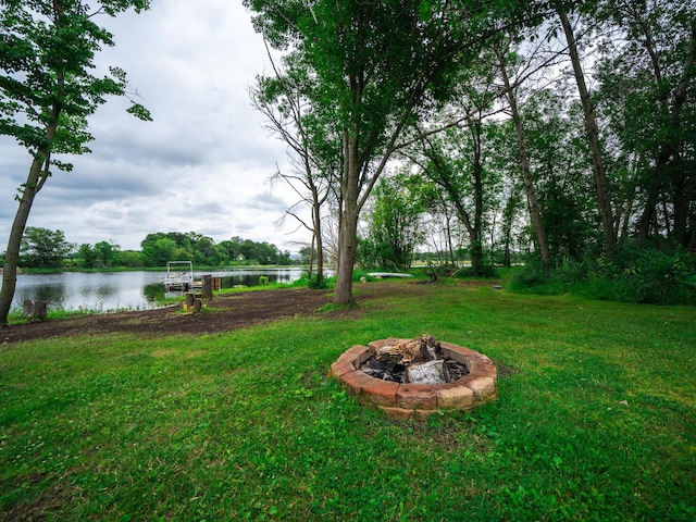 view of yard with a water view and a fire pit