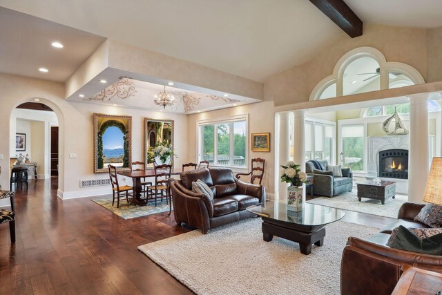 living room featuring dark wood-type flooring, beam ceiling, high vaulted ceiling, a fireplace, and a chandelier