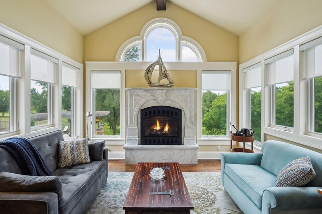 sunroom with vaulted ceiling with beams and a healthy amount of sunlight