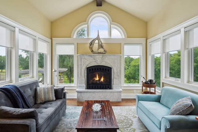 sunroom featuring a high end fireplace, vaulted ceiling, and a healthy amount of sunlight