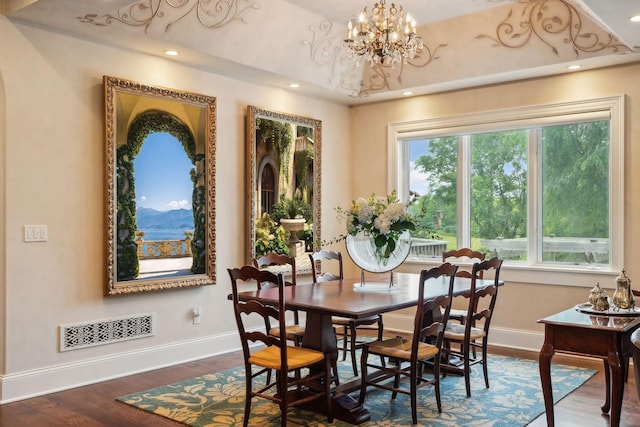 dining space with a mountain view, dark wood-type flooring, and an inviting chandelier