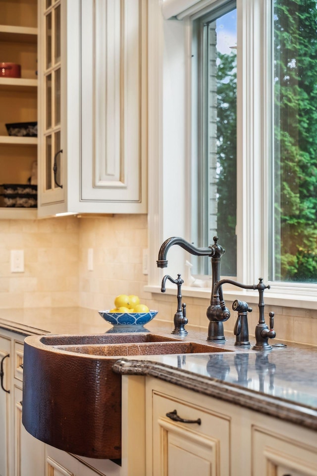 kitchen with sink, tasteful backsplash, and cream cabinetry