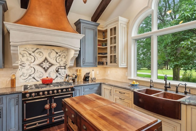 kitchen with double oven range, cream cabinets, custom exhaust hood, and gray cabinetry