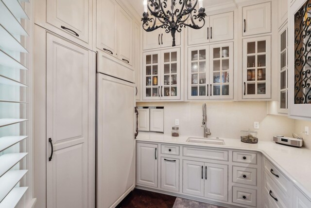 kitchen featuring white cabinetry, sink, and a chandelier