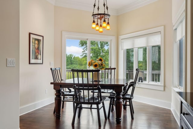 dining area featuring ornamental molding, dark wood-type flooring, and an inviting chandelier