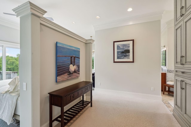 hall with light carpet, ornate columns, and crown molding