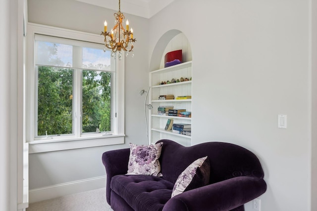 living area featuring carpet flooring and an inviting chandelier