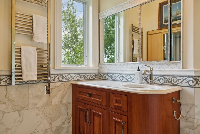 bathroom featuring vanity, radiator heating unit, and tile walls