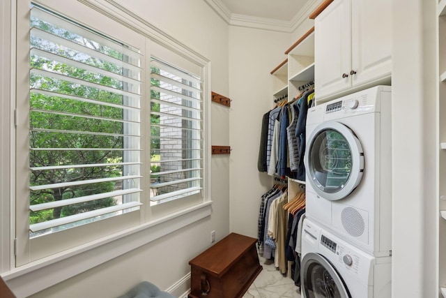 washroom with stacked washer / dryer, cabinets, and ornamental molding