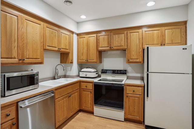 kitchen with light hardwood / wood-style flooring, sink, and stainless steel appliances