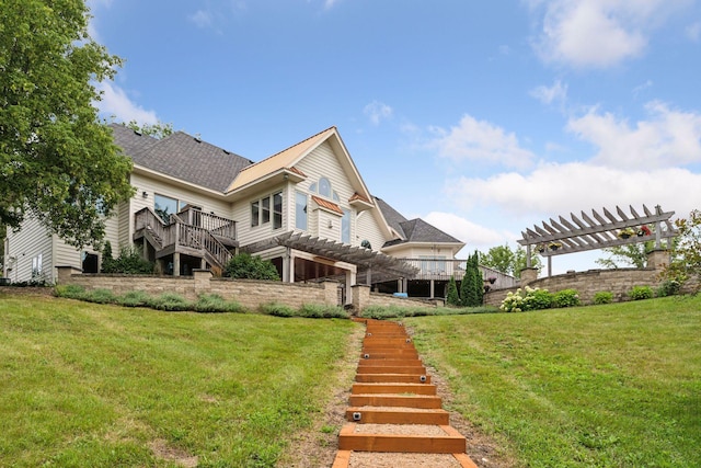 rear view of property featuring a yard, a wooden deck, and a pergola