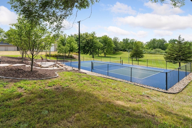 view of tennis court featuring a yard