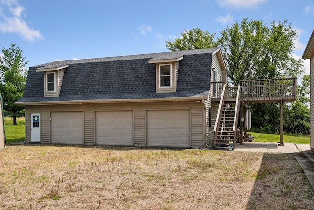 view of property exterior with a lawn, a garage, and a wooden deck