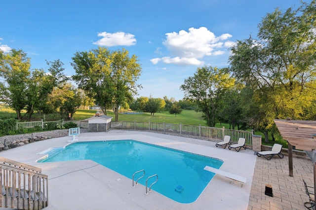 view of pool with a diving board and a patio area