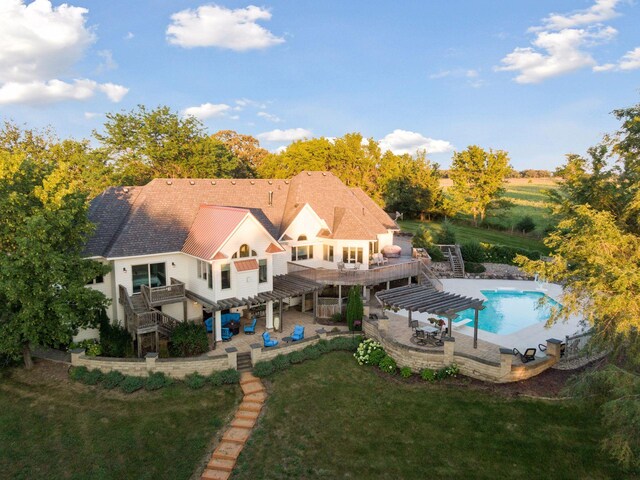 rear view of property with a yard, a patio, a pergola, and a swimming pool side deck