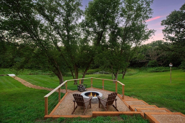 yard at dusk featuring an outdoor fire pit