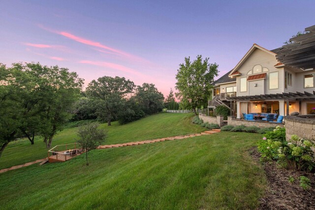 yard at dusk featuring an outdoor living space, a pergola, and a patio