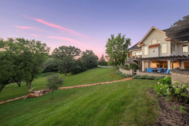 yard at dusk with an outdoor hangout area, a deck, and a patio area