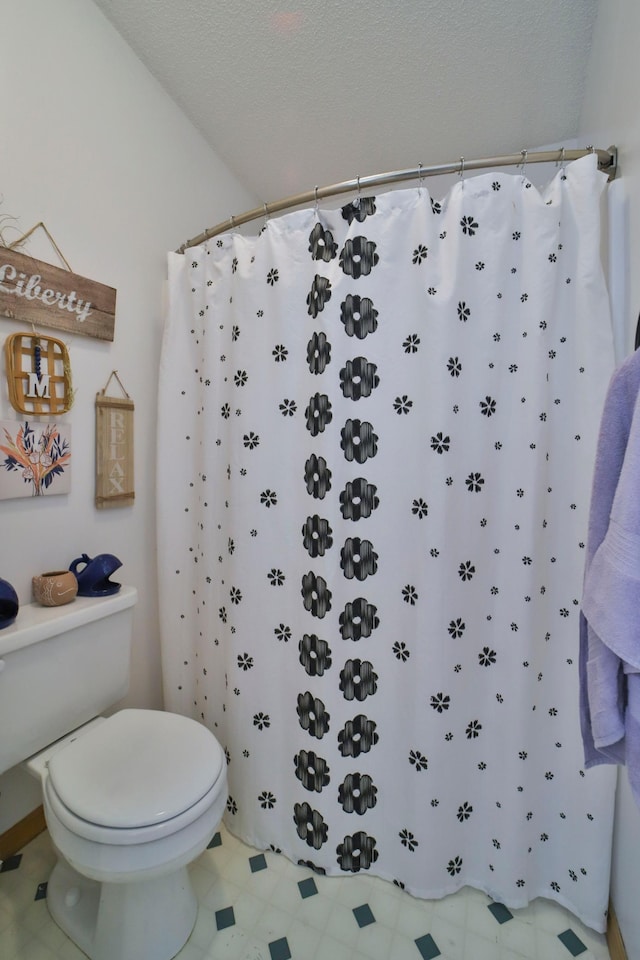 bathroom featuring a shower with shower curtain and toilet