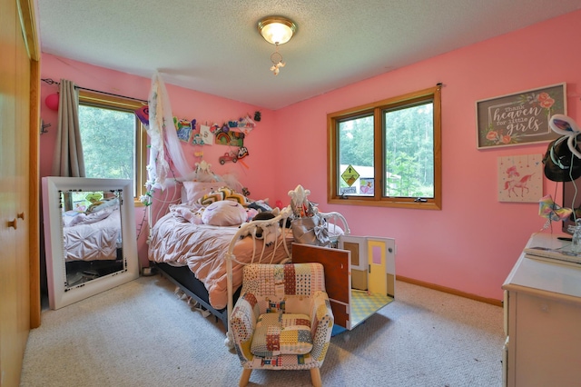 bedroom with multiple windows, light carpet, and a textured ceiling