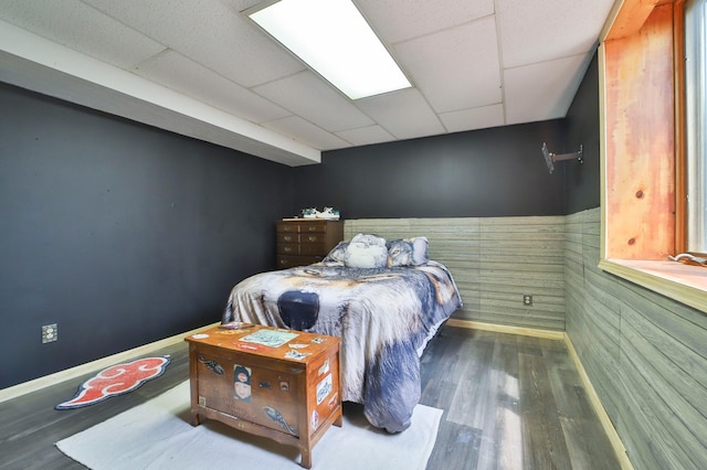 bedroom with a drop ceiling and hardwood / wood-style flooring