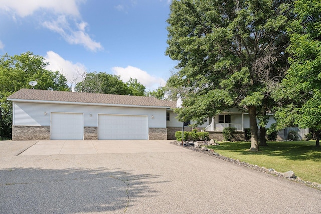 view of front of property with a front lawn, a garage, and covered porch