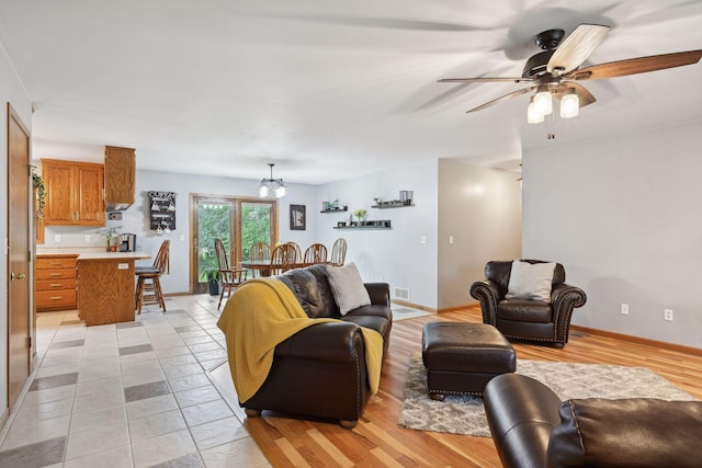 living room with ceiling fan and light wood-type flooring