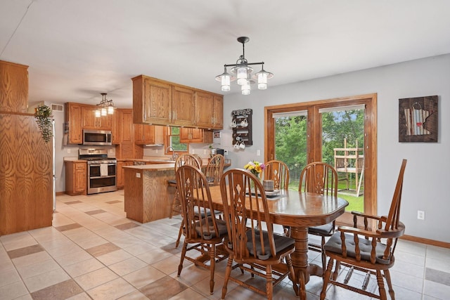 tiled dining room with sink and a chandelier