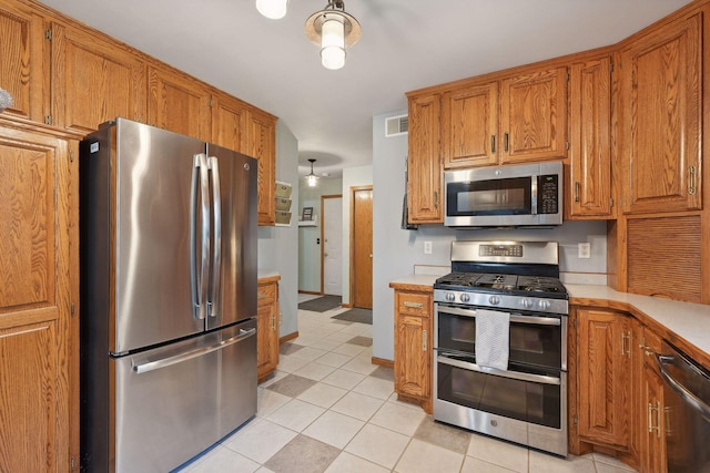 kitchen featuring light tile patterned floors and stainless steel appliances