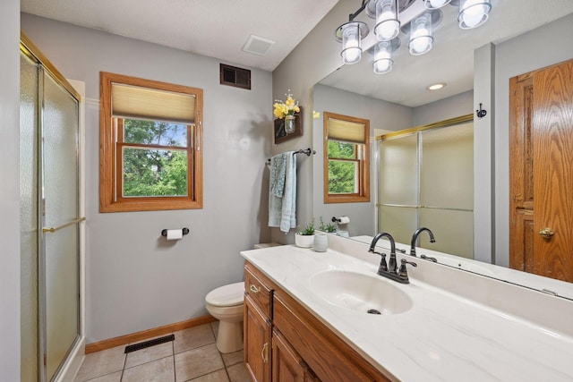 bathroom featuring a shower with shower door, toilet, and a healthy amount of sunlight