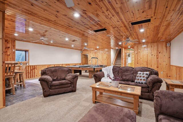 living room with carpet flooring, ceiling fan, wooden walls, and wooden ceiling