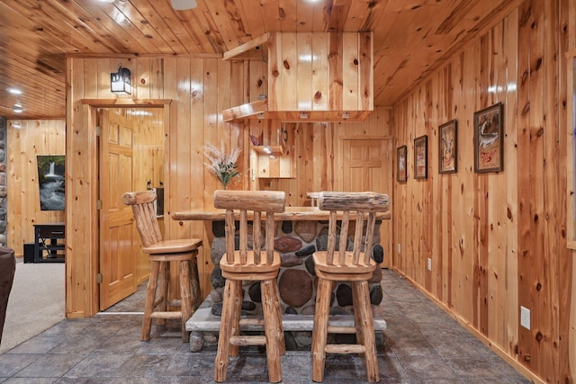 dining space with wood walls and wood ceiling